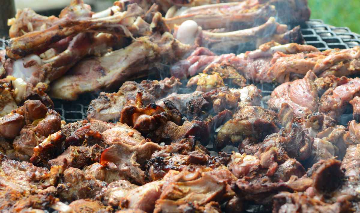 Uma grelha de churrasco com carne demais sobre ela.