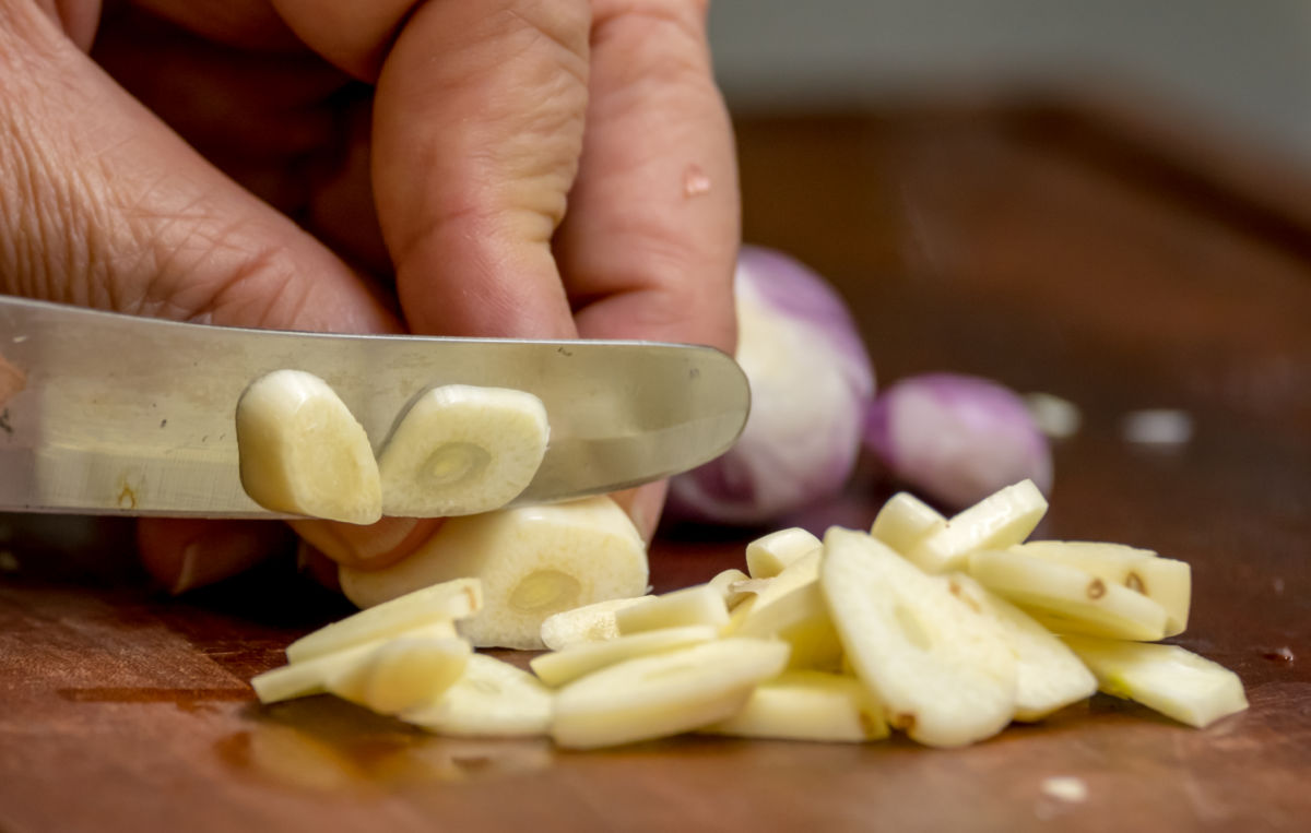 Cortando dentes de alho para repelir formigas.