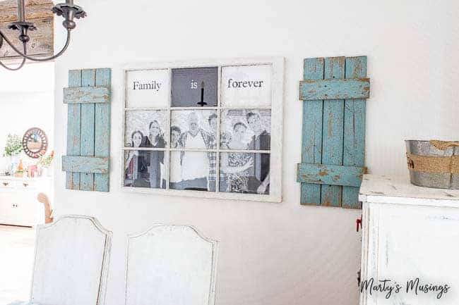 Placa ‘a família é para sempre’ em vidro de janela com persianas azuis