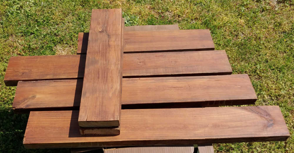 Madeira tratada sob pressão, manchada com verniz exterior para fazer uma cama de jardim elevada fácil.