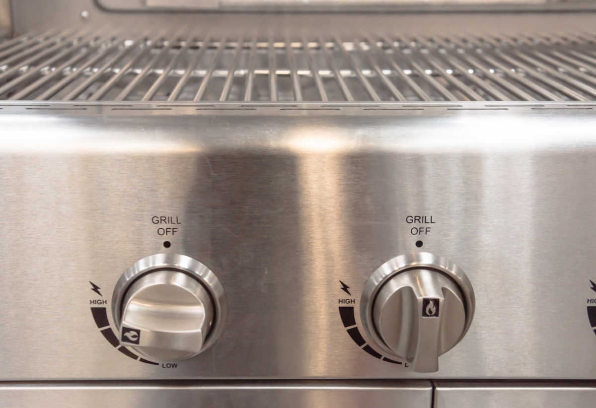 Botões de um churrasco a gás ajustados para pré-aquecimento antes de cozinhar.
