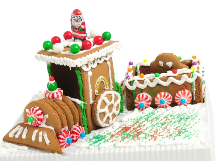 Trem feito de gengibre com enfeites de doces e glacê real com confeitos para simular neve.