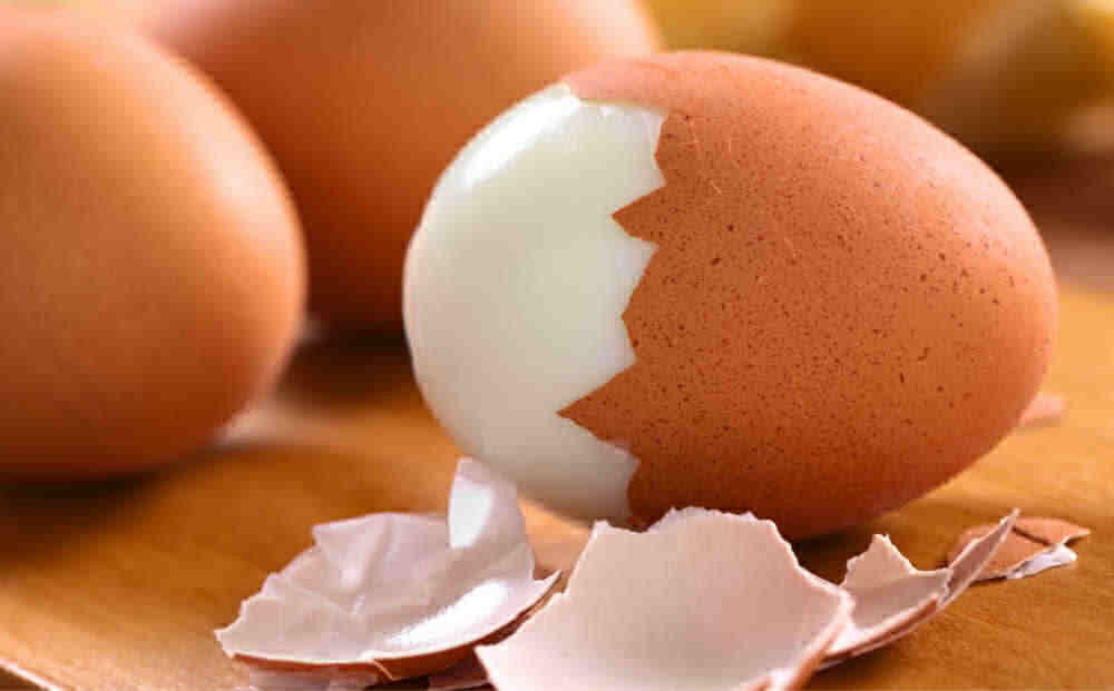 Ovos cozidos com a casca meio retirada do ovo.