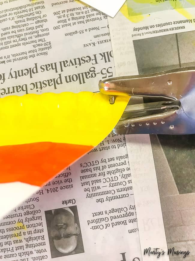 Quer um artesanato fácil de Halloween ou de outono? Este banner de candy corn é super fácil e feito com um prato de papel! Perfeito para crianças! fure um buraco no banner de candy corn