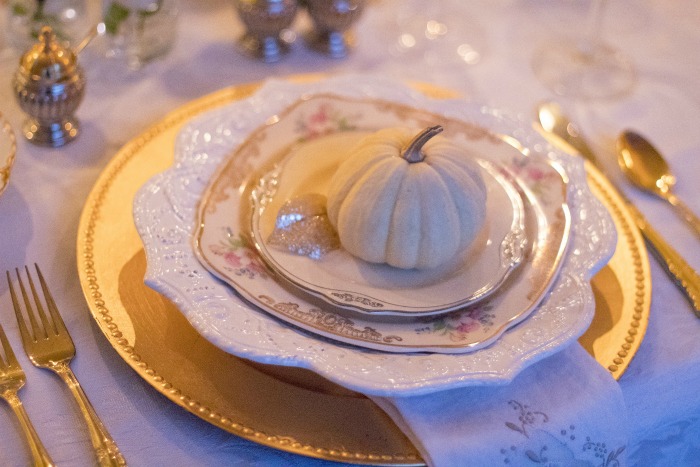 white pumpkins on individual table settings configuração de mesa de feriado com pequena abóbora
