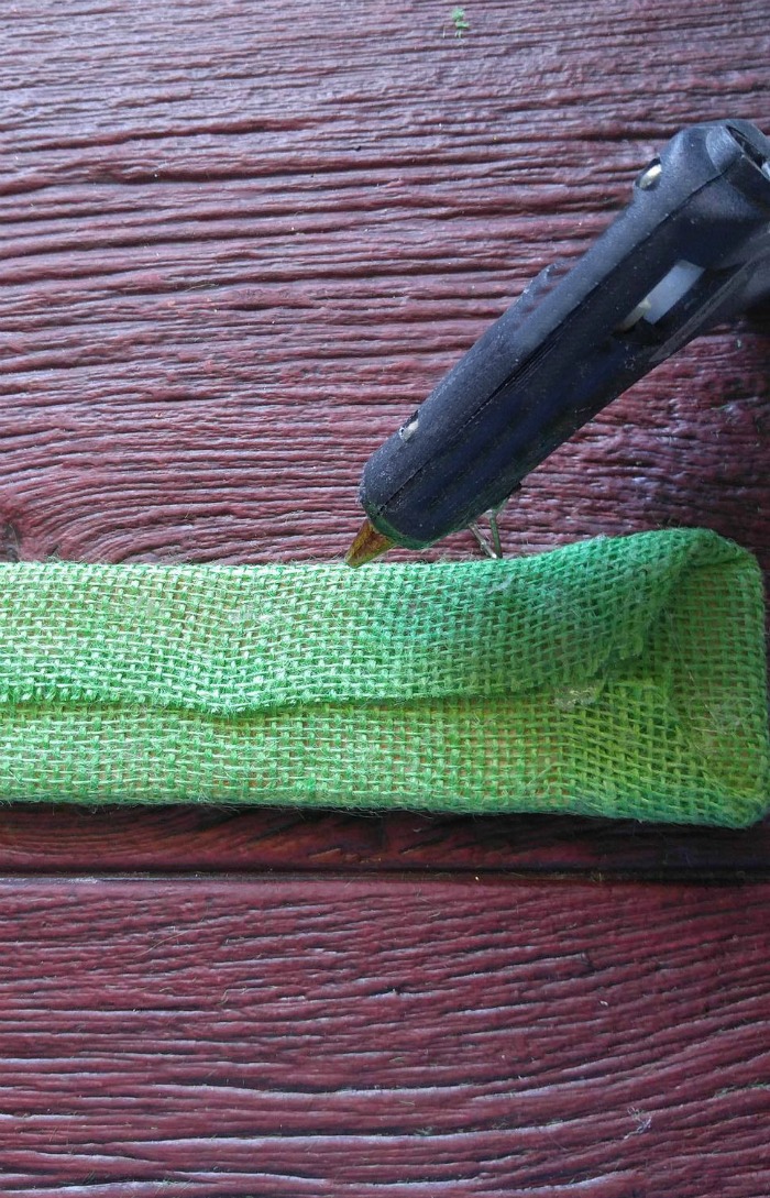 Pistola de cola quente e material de juta verde.