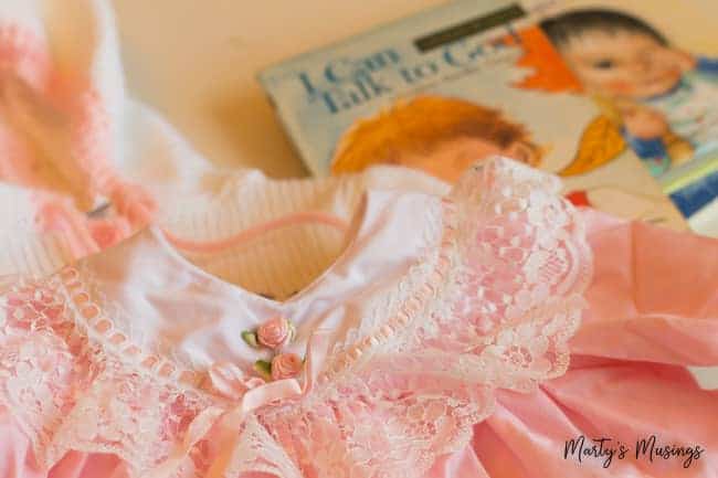 Vestido de bebê rosa e branco com livro de bebê
