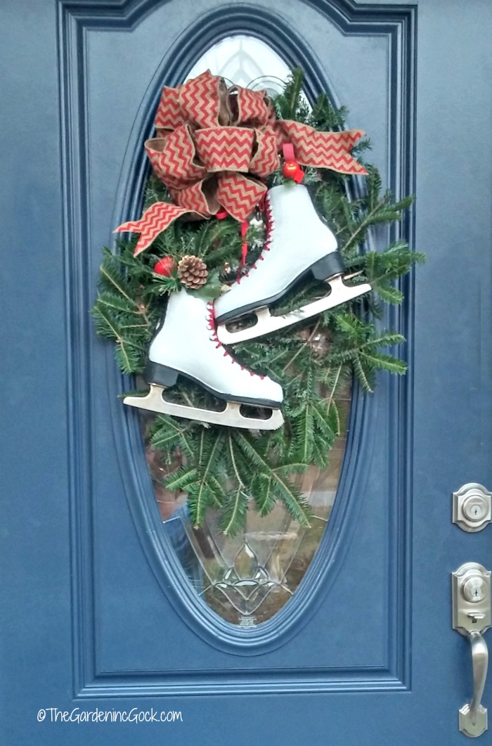 Esta guirlanda festiva de patins de gelo parece perfeita em uma porta da frente com um painel de vidro oval. Os patins adicionam um toque divertido ao laço de juta e conferem a todo o projeto um visual campestre. thegardeningcook.com