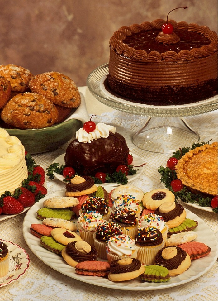 Bolo, muffins, doces e outras comidas de Natal em pratos.