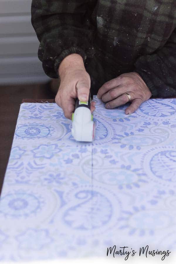Cortando tecido para valance de janela em madeira compensada