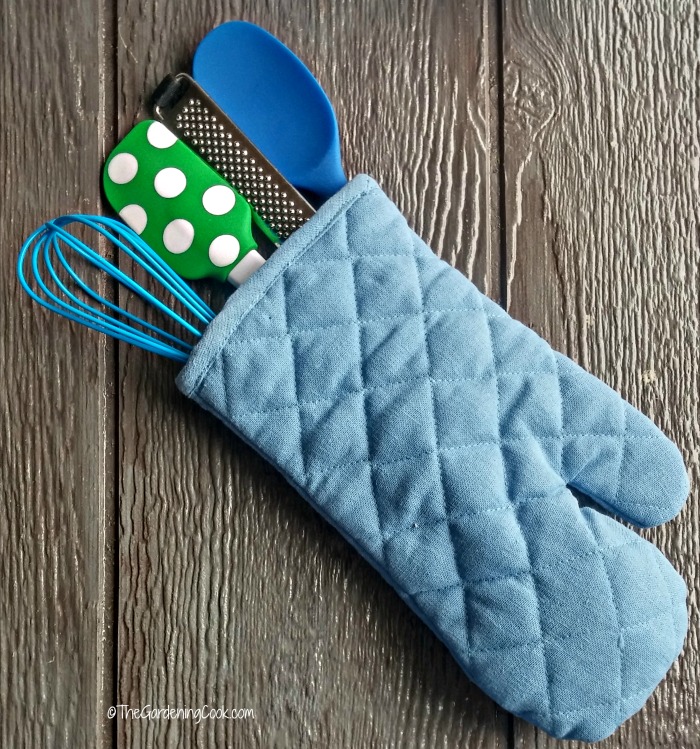 Suporte azul cheio de ferramentas de cozinha de silicone.