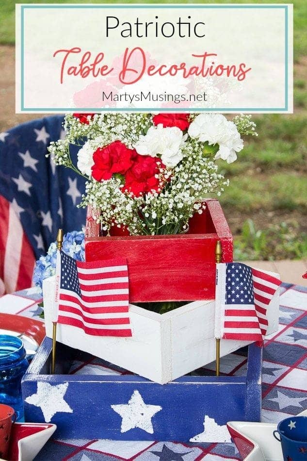 Decorações baratas para a mesa do 4 de Julho, feitas com achados de vendas de garagem, brechós e itens que já temos em casa, com flores da estação, criam um cenário rústico e perfeito ao ar livre. Caixa vermelha, branca e azul com cravos vermelhos e brancos para o 4 de Julho