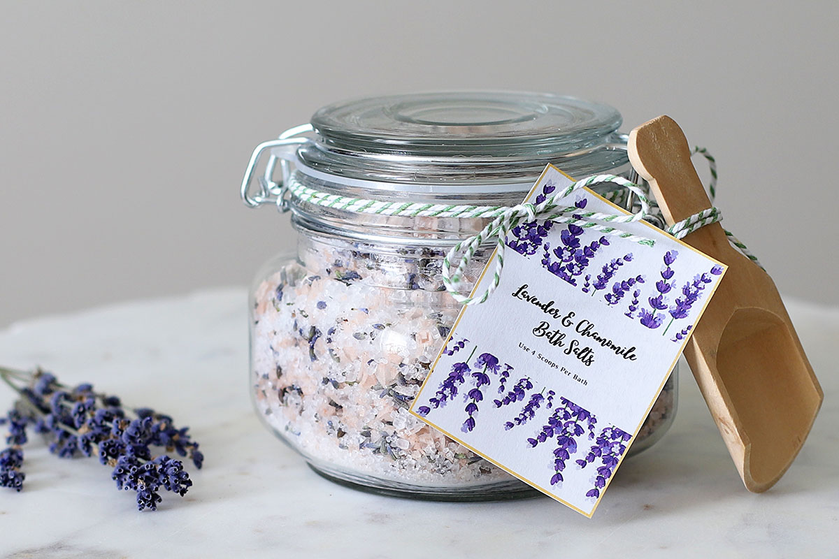 Sais de banho de lavanda e camomila DIY em um pote de vidro com uma colher de madeira.