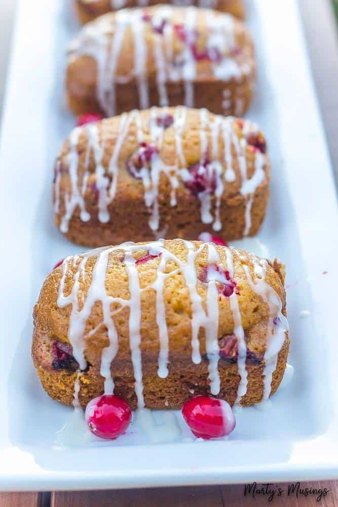 Esta receita fácil de Pão Rápido de Abóbora com Cranberry logo se tornará uma das favoritas da família. Coberto com uma cobertura simples, o pão é perfeito o ano todo! Pão de cranberry e abóbora com cobertura