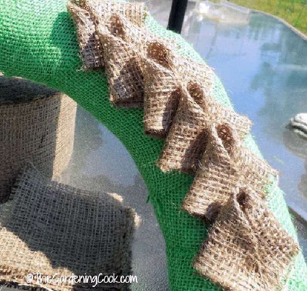 Pétalas de juta marrom no centro de uma forma de guirlanda de juta verde.