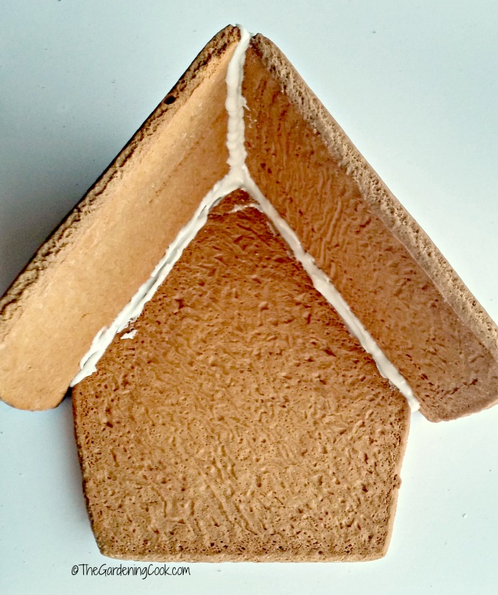 Glacê real aplicado às peças da casa de gengibre para prender o telhado da casa à lateral.
