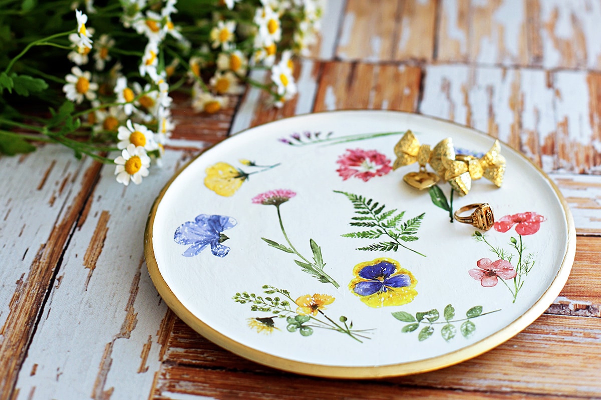 Dê uma repaginada em decorações de brechó de forma econômica! Aprenda como usar transfers em achados de brechó reutilizados para criar peças de decoração de madeira deslumbrantes. Este fácil DIY adiciona charme a bandejas, tigelas e muito mais!