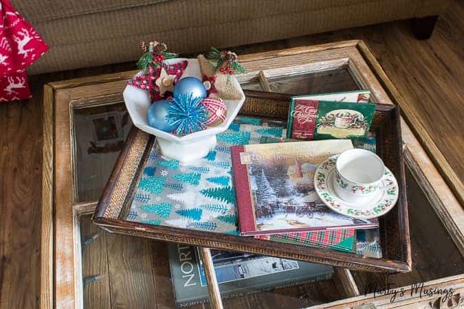 Mesa de janela com bandeja e enfeites de Natal azuis e vermelhos em uma tigela