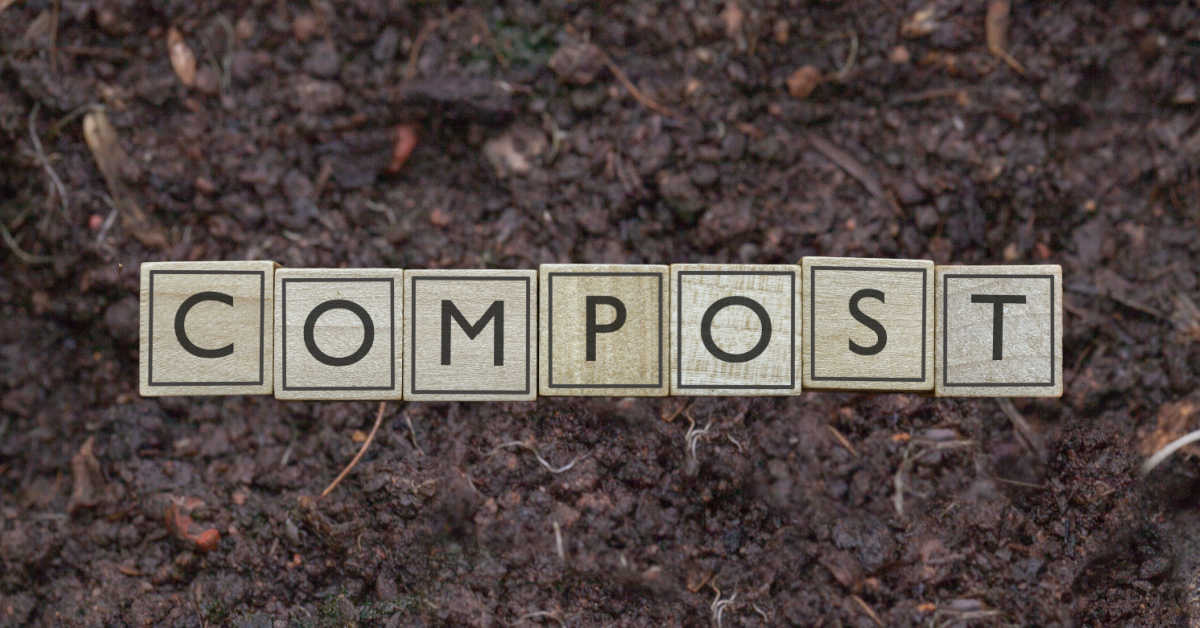 Solo de jardim com blocos que dizem compostagem.