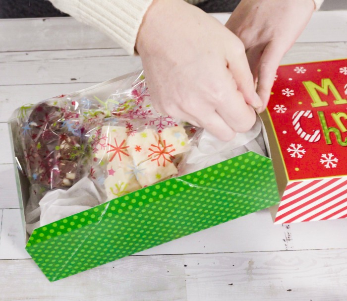Embrulhando fudge para presentes. Embrulhando fudge em plástico em uma caixa de presente de Natal.