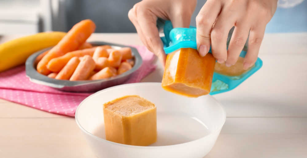 mãos liberando comida de formas de gelo de silicone.