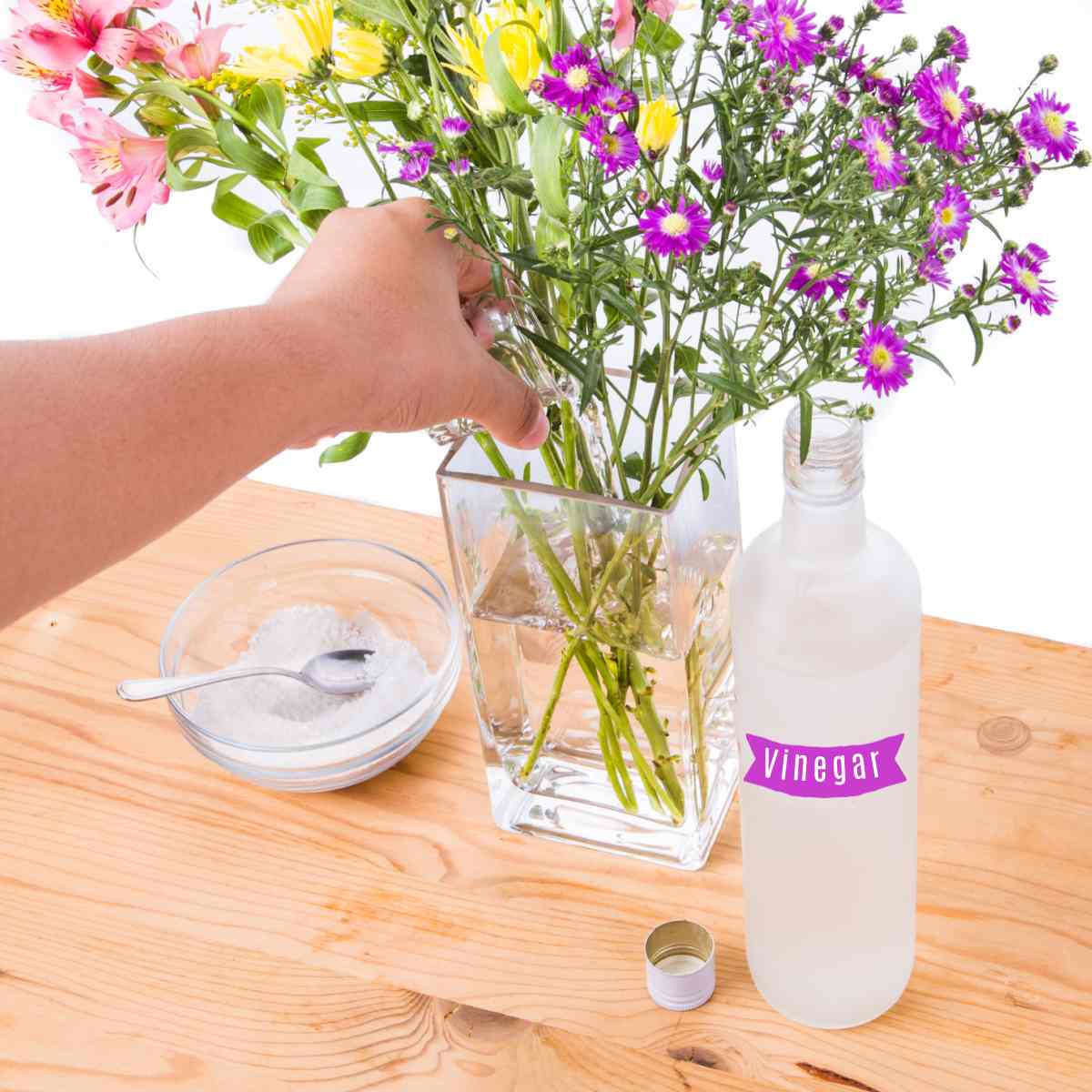 Adicionando vinagre e açúcar às flores em um vaso.